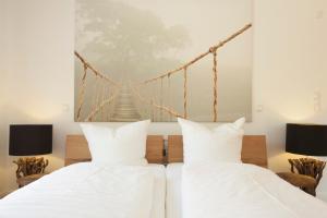 a bedroom with two beds and a suspension bridge painting on the wall at Gustls-Hus, Wohnung 6 in Kellenhusen