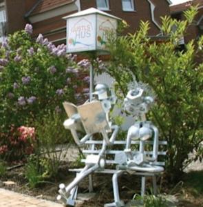 two robots sitting on a bench in a garden at Gustls-Hus, Wohnung 6 in Kellenhusen