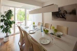 a dining room table with chairs and a large window at Gustls-Hus, Wohnung 6 in Kellenhusen