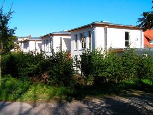 ein weißes Haus mit Büschen davor in der Unterkunft Ferienhaus in Heiligendamm mit Sauna & Kamin - [#23967] in Heiligendamm