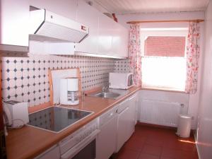 a small kitchen with a sink and a microwave at Silva Mare, OG 1 in Kellenhusen