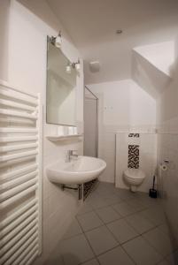 a white bathroom with a sink and a toilet at Haus Strandgang, Whg 2 in Kellenhusen