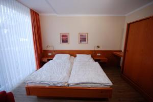 a small bedroom with two beds and a window at Haus Strandgang, Whg 2 in Kellenhusen