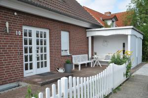 a white fence in front of a brick house at Haus Jodokus, Whg Professor Paljass in Kellenhusen