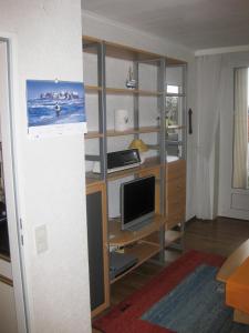a room with a desk with a computer and a television at Haus Nautic 4-3-6 in Kellenhusen