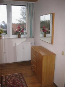 a room with two windows and a dresser with flowers in it at Haus Nautic 4-3-6 in Kellenhusen