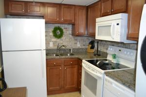ピジョン・フォージにあるRiver Place Condos #107 2BDの木製のキャビネットと白い冷蔵庫を備えたキッチン