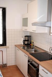 a kitchen with white cabinets and a sink at Ferienwohnung Eichhörnchen in Braunlage