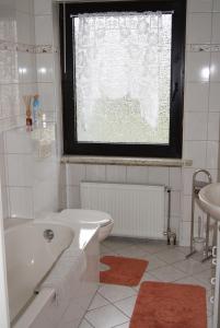 a white bathroom with a tub and a sink at Ferienwohnung Eichhörnchen in Braunlage