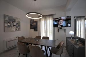 a dining room with a table and chairs and a tv at Blue diamonds villas Paros in Pounda