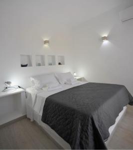 a white bedroom with a large bed and two lights at Blue diamonds villas Paros in Pounda