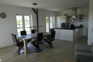 a dining room and kitchen with a table and chairs at Nordlicht II in Trent