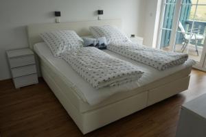 トレントにあるNordlicht IIの白いベッド(枕付)が備わる客室です。