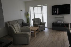 a living room with a couch and two chairs and a tv at Nordlicht II in Trent