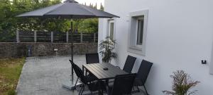 a table and chairs with an umbrella on a patio at white rose in Potamós