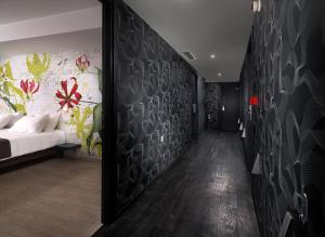 a bedroom with a bed and a wall with flowers at Airotel Patras Smart Hotel in Patra