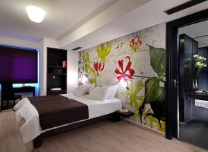 - une chambre avec un lit et un mur fleuri dans l'établissement Airotel Patras Smart Hotel, à Patras