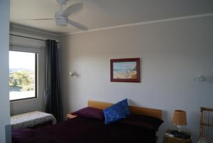 a bedroom with a bed and a window at Hyview in Paihia