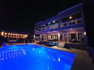 a swimming pool in front of a house at night at Fishers Landing Boutique Hotel in Roatan