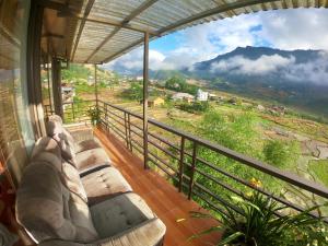 a balcony with couches and a view of a mountain at Amica House in Sa Pa
