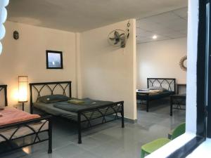 Habitación con 2 camas y 2 sillas en Homestay Vườn Pháp II, en Buon Ma Thuot