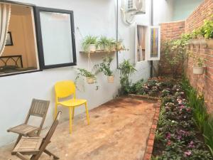 a patio with a yellow chair and some plants at Homestay Vườn Pháp II in Buon Ma Thuot