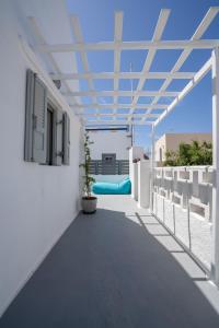 a balcony with a white building with a ceiling at Casa Sigala arch in Oia