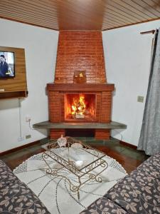 a fireplace in a living room with a table in front of it at Apartamento em Campos do Jordão próximo ao Capivari in Campos do Jordão
