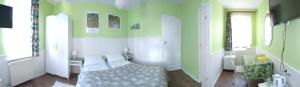 a bedroom with green and white walls and a bed at Noclegi - Przy Porcie in Łeba