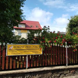 a sign on a fence in front of a house at Noclegi - Przy Porcie in Łeba