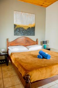 a bed with a wooden frame with a blue towel on it at Tierra Viva in Puerto Iguazú