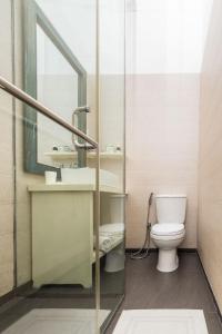 a bathroom with a toilet and a sink and a mirror at The Entrance Galle Fort in Galle