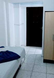 a bedroom with a bed and a black door at Hotel Piazza Batel in Curitiba