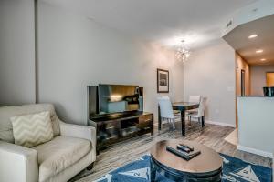 a living room with a couch and a tv and a table at Newly Renovated Ocean Front Condo, Modern Decor, Central MB, 20th floor in Myrtle Beach