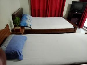 - une chambre avec 2 lits et une télévision dans l'établissement Marry House, à Dhaka