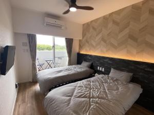 a bedroom with two beds and a ceiling fan at HYGGE Biimata in Nago +17 photos