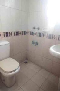 La salle de bains est pourvue de toilettes et d'un lavabo. dans l'établissement Marry House, à Dhaka