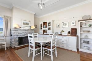 a kitchen with a table and chairs and a fireplace at The White House Prime Location and Oozing Character in Apollo Bay