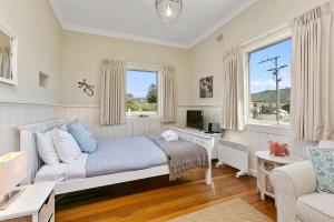 a bedroom with a bed and a couch and a window at The White House Prime Location and Oozing Character in Apollo Bay