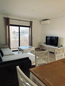a living room with a couch and a tv and a table at Casa Marta e Casa Francisco in Olhão
