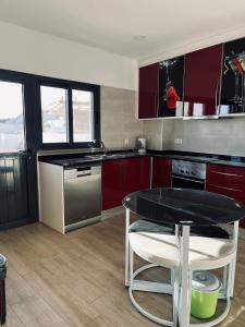 a kitchen with red cabinets and a black table at Casa Marta e Casa Francisco in Olhão +20 photos