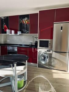 a kitchen with red cabinets and a washer and dryer at Casa Marta e Casa Francisco in Olhão
