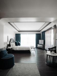a bedroom with a bed and a room with a couch at Burirattana Hotel-An Adults Only Hotel in Chiang Mai