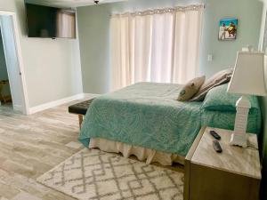 a bedroom with a bed and a table with a lamp at Gulf to Golf. in Bradenton