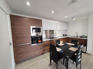 a kitchen with a black table and chairs in a room at Lovely home close to City Center & Rail Station in Chesterfield