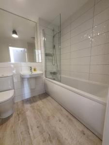 a bathroom with a tub and a sink and a toilet at Lovely home close to City Center & Rail Station in Chesterfield