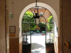 un arco que conduce a un patio con patio en Casa Di Santa Francesca Romana a Ponte Rotto, en Roma