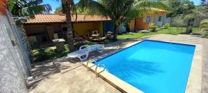 a large swimming pool in front of a house at Guest House LuLi in Búzios