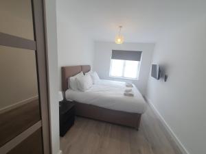 um pequeno quarto com uma cama e uma janela em Lovely home close to City Center & Rail Station em Chesterfield