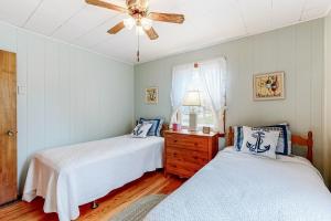 Un dormitorio con dos camas y un ventilador de techo. en Anchors Await, en South Yarmouth